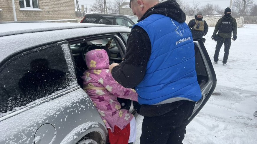 Представник "Проліски" садить жінку в машину під час евакуації із Донеччини. Євген Ткачов/Facebook